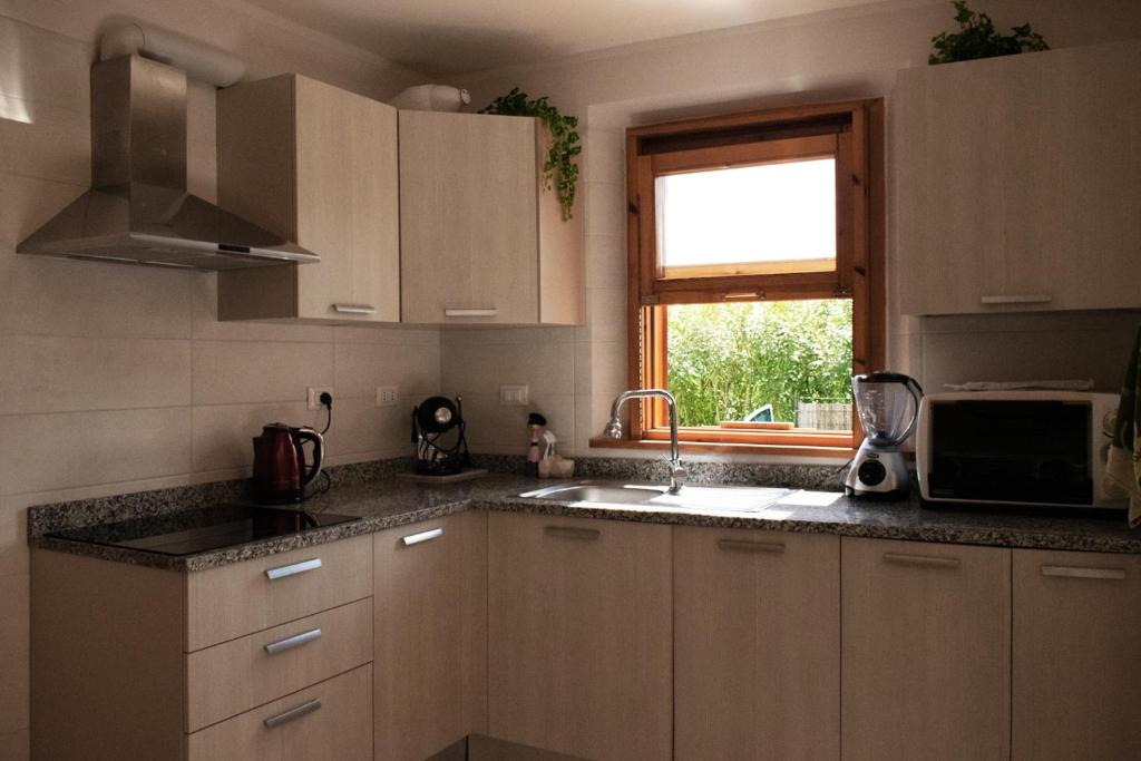 a kitchen with white cabinets and a window and a sink at La villetta fonte antica "parcheggio privato" 700m dalle spiagge e dal centro in Numana