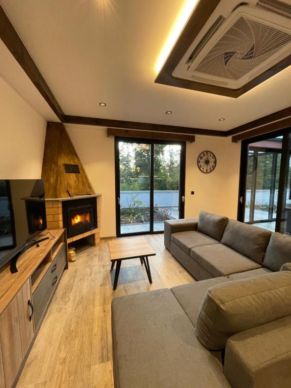 a living room with a couch and a fireplace at Casa Requinte - Jacuzzi in Arco da Calheta