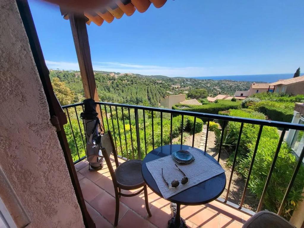 un balcon avec une table et des chaises et une vue dans l'établissement Maison charmante à Roquebrune-sur-Argens avec piscine partagée, à Roquebrune-sur Argens