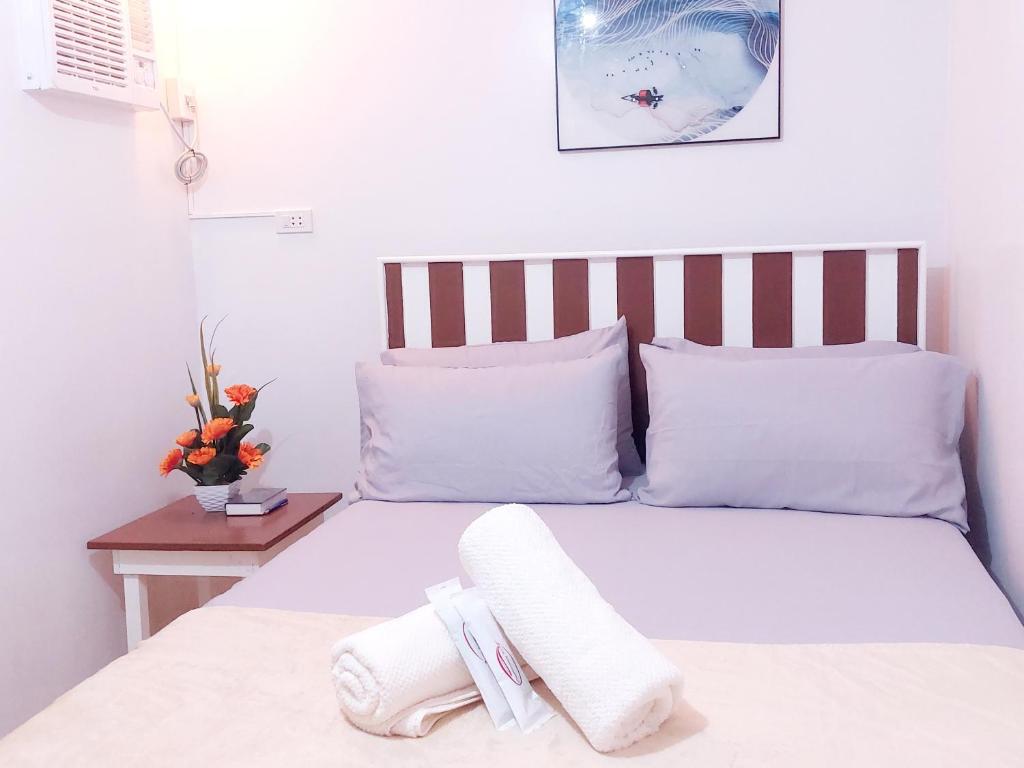 a bedroom with a white bed with white pillows at Rics Staycation at Urban Deca Homes Marilao, Bulacan in Marilao
