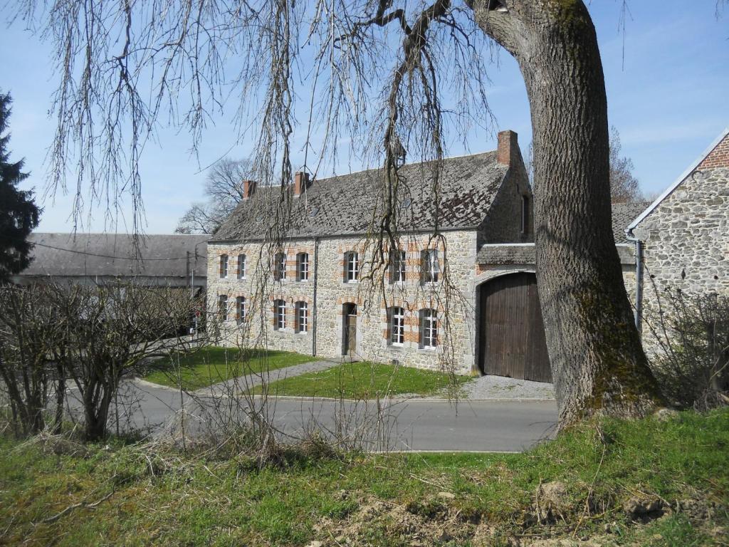 uma antiga casa de pedra com uma grande garagem em Ferme De Guersignies B&B em Bas-Lieu