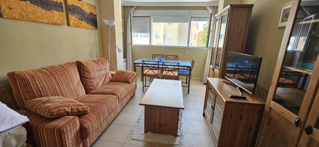 - un salon avec un canapé et une télévision dans l'établissement Apartamento Sierra Nevada, à Sierra Nevada