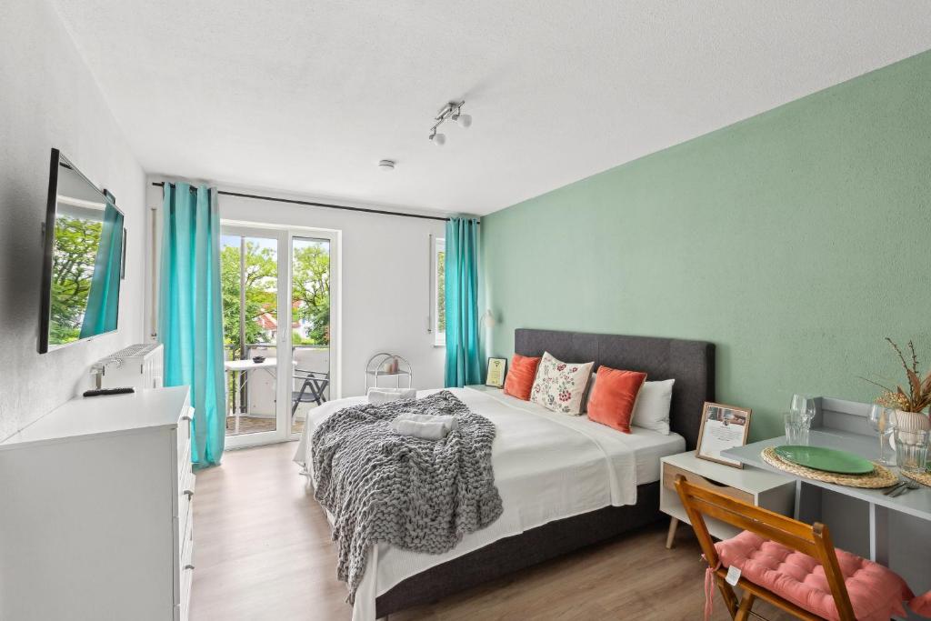 Schlafzimmer mit einem Bett, einem Schreibtisch und einem Fenster in der Unterkunft Salí Homes LM1 Studio mit guter Anbindung an die A9 in Bayreuth