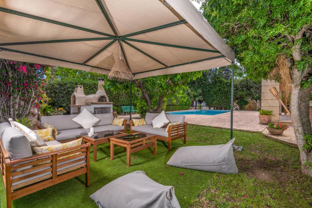 a patio with couches and an umbrella next to a pool at Havre de Paix in Tunis