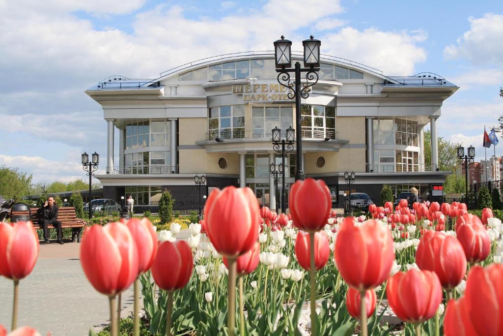 a building with red and white tulips in front of it at Sheremetev Park Hotel in Ivanovo