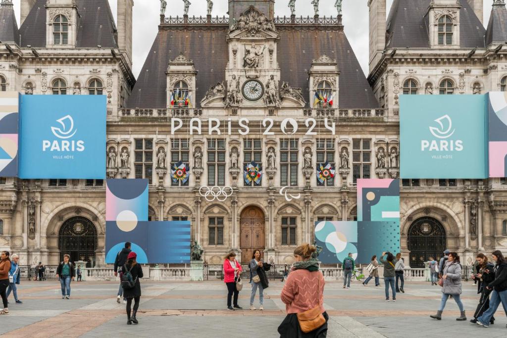 personas caminando frente a un gran edificio en La Suite Le Marais, en París