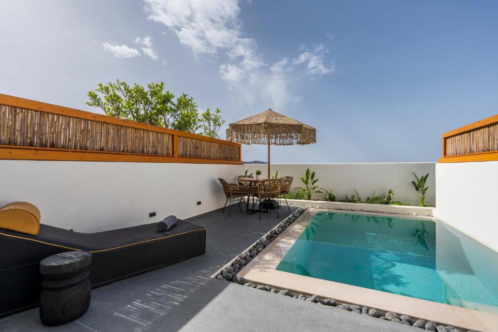 un patio al aire libre con piscina y mesa en La Torretta, en Pirgos