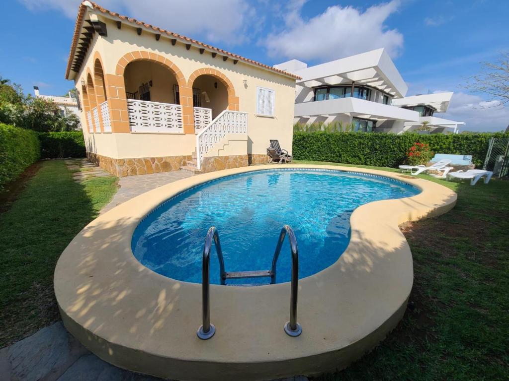 a swimming pool in front of a house at Sol y Mar in Oliva