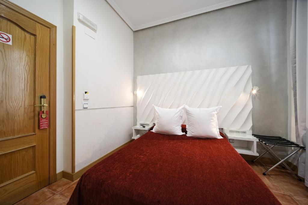 una camera con un letto con due cuscini bianchi di Hostal Las Fuentes a Madrid