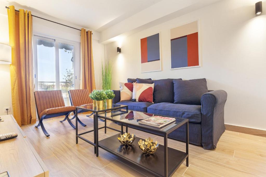 een woonkamer met een blauwe bank en een tafel bij Metropolitano en Madrid in Madrid