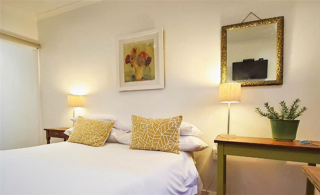 Johannesburg的住宿－The Melville Quarters，卧室配有一张床,墙上设有镜子