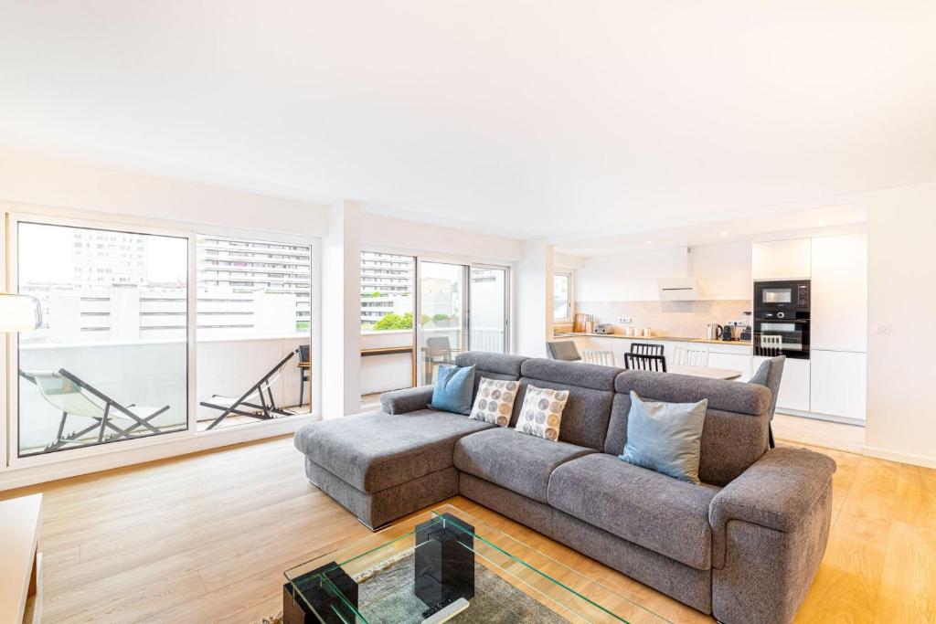 un salon avec un canapé et une cuisine dans l'établissement GuestReady - Apt avec Balcon à la Place d'Italie, à Paris
