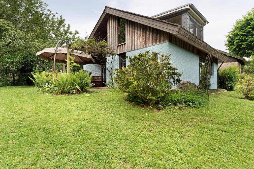 una casa con un patio de hierba delante de ella en Ferienhaus Karlsminde, en Waabs