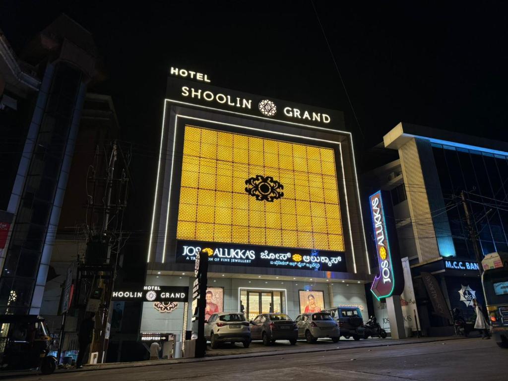 una tienda con un gran cartel amarillo en la parte delantera en Hotel Shoolin Grand en Mangalore