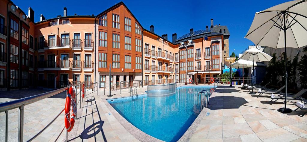 a swimming pool in front of some buildings at Apartahotel & Spa Jacetania in Jaca