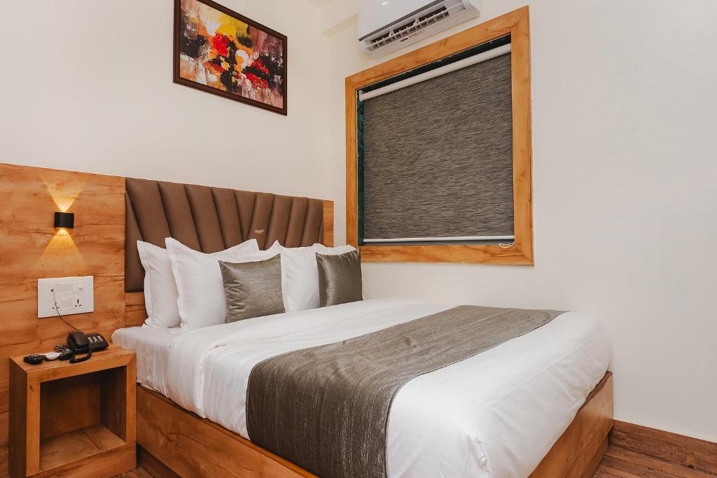 sypialnia z dużym łóżkiem i oknem w obiekcie FabHotel Airport Palace w Bombaju