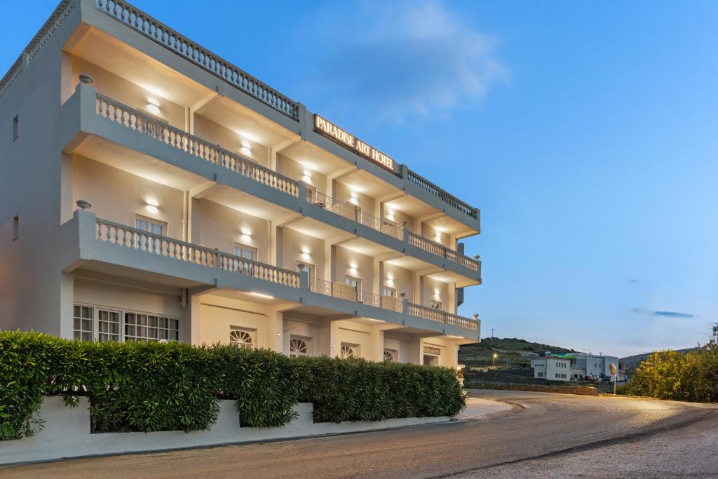 un gran edificio blanco con balcones en una calle en Paradise Art Hotel en Andros