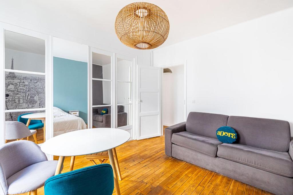 un salon avec un canapé, une table et des chaises dans l'établissement GuestReady - Subway style in classy Auteuil, à Paris