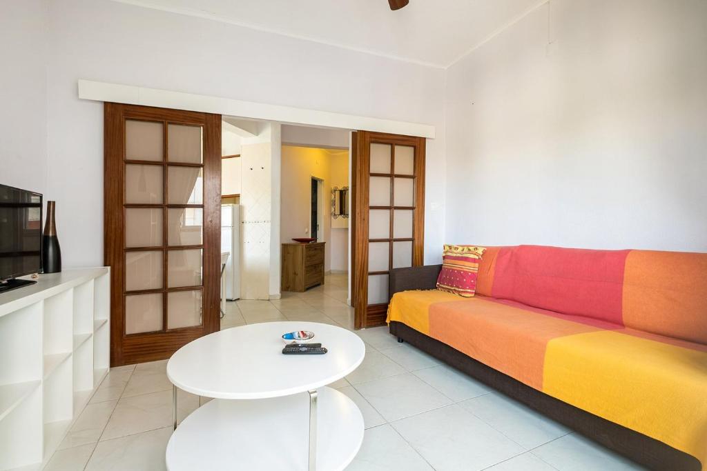 een woonkamer met een kleurrijke bank en een tafel bij GuestReady - Enchanting Retreat in Paço de Arcos in Paço de Arcos