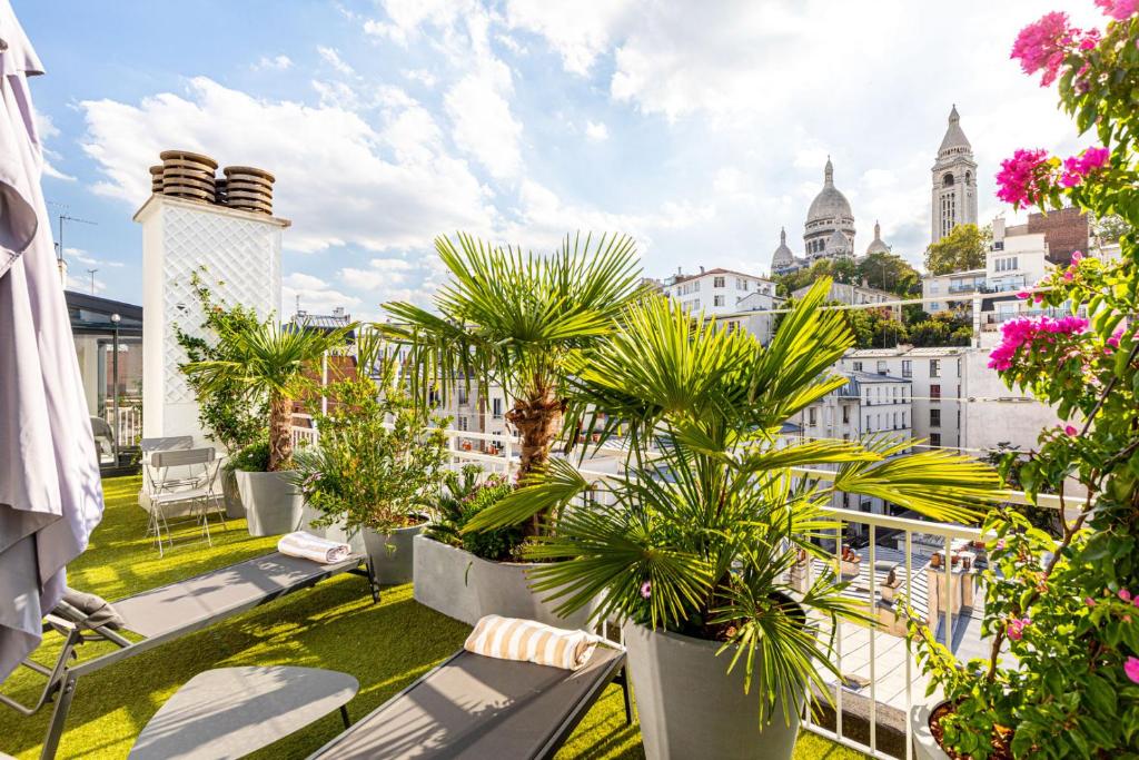 d'un balcon avec des palmiers et une vue sur la ville. dans l'établissement GuestReady - Paris Charm with Montmartre View, à Paris