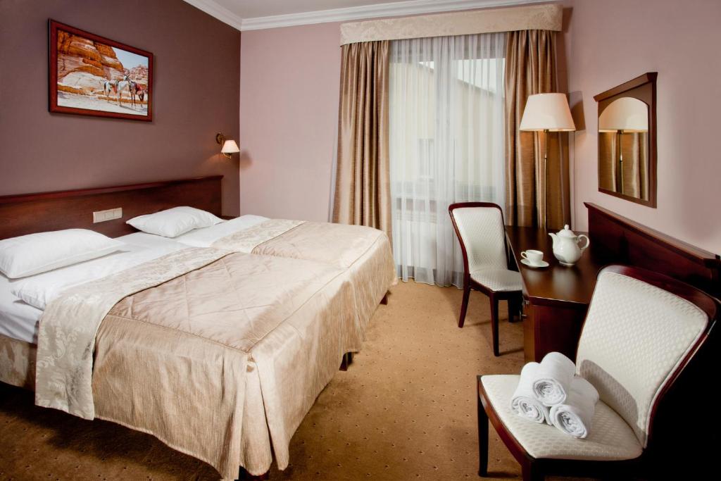 um quarto de hotel com uma cama, uma mesa e cadeiras em Pensjonat Poniatowski em Suchowola