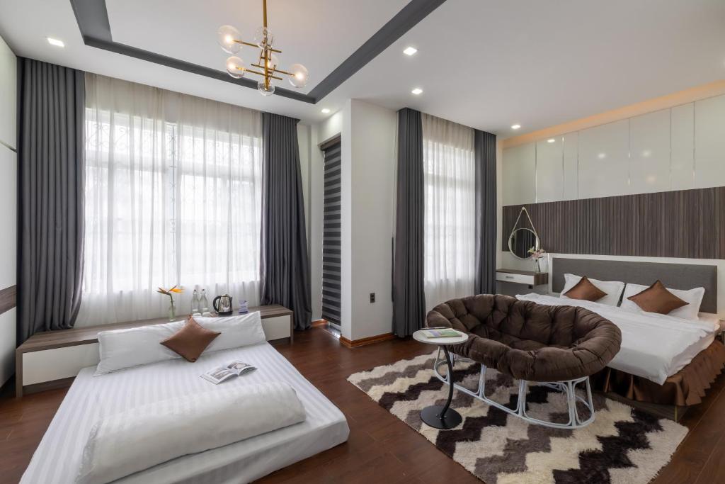 a bedroom with two beds and a couch and a chair at Teky House Huế in Thôn Trường Giang