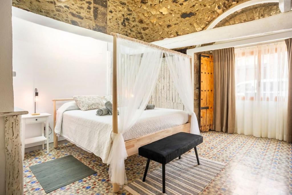 1 dormitorio con 1 cama con dosel en Alojamiento Rural Can Picas, en Cantallops