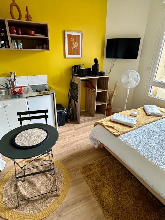 une chambre avec un lit, une table et un bureau dans l'établissement Le Joli-Mans - Gare - BCLA, au Mans