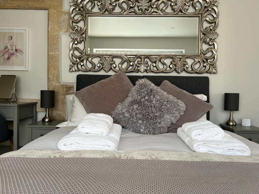 バースにあるCosy countryside stay near Bath with free parkingのベッド1台(タオル2枚、鏡付)