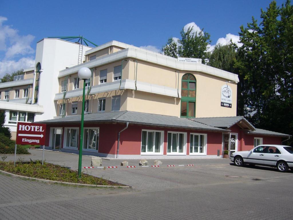 a building with a car parked in front of it at Hotel Garni Stadt Friedberg in Friedberg