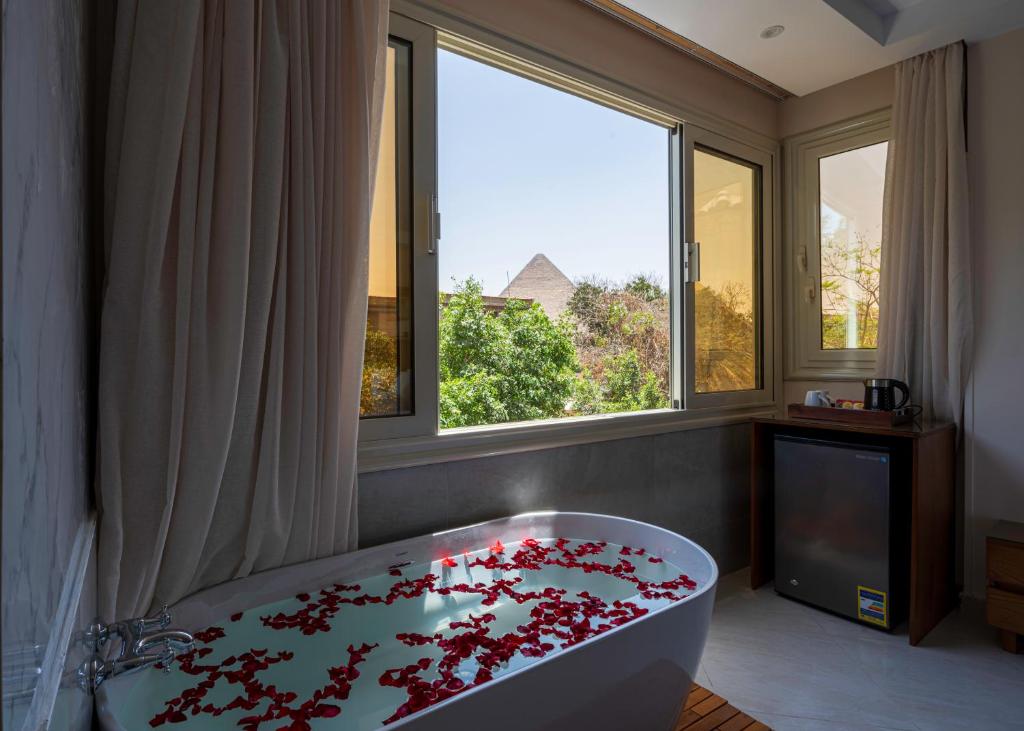 a bathroom with a tub filled with red flowers at Dream Inn in Cairo