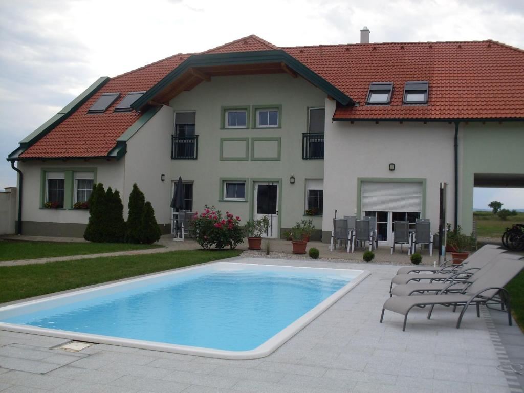a house with a swimming pool in front of a house at Urbarialhof in Illmitz