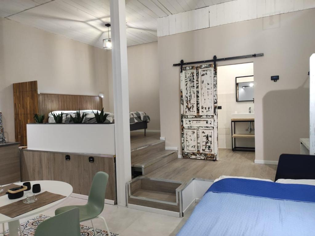 ein Schlafzimmer mit einem Bett und einem Tisch sowie ein Zimmer in der Unterkunft Al Settimo porta marina in Syrakus