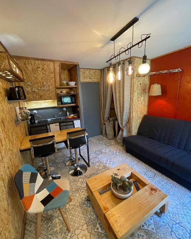 un salon avec un canapé bleu et une table dans l'établissement Le Pélican, à Saint-Georges-de-Didonne