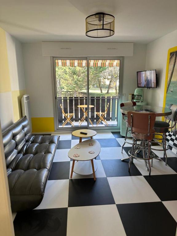 - un salon avec un canapé et un sol en damier dans l'établissement Studio Sixties, à Saint-Georges-de-Didonne
