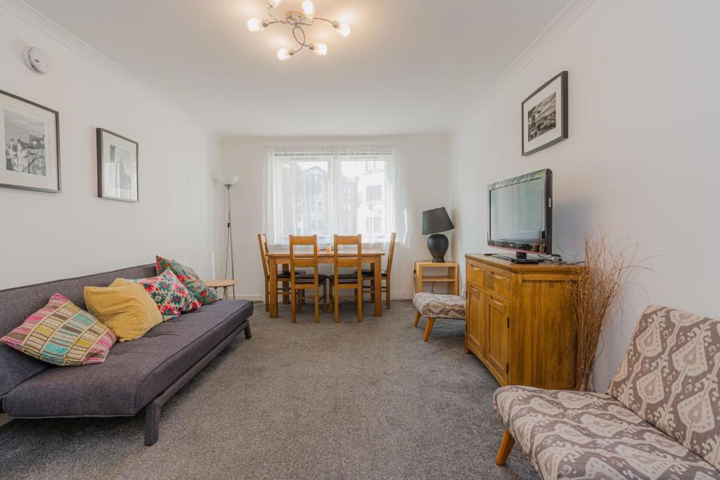 een woonkamer met een bank en een tv bij GuestReady - Restful stay near Edinburgh Castle in Edinburgh