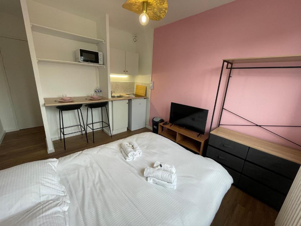 une chambre avec un lit avec deux serviettes dessus dans l'établissement Roza, Studio proche centre ville, à Caen