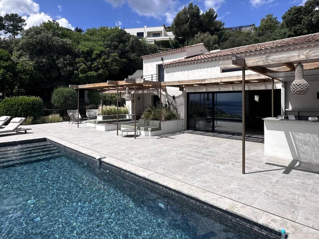 een huis met een zwembad en een patio bij Villa Les Issambres, 8 pièces, 14 personnes - FR-1-768-62 in Les Issambres
