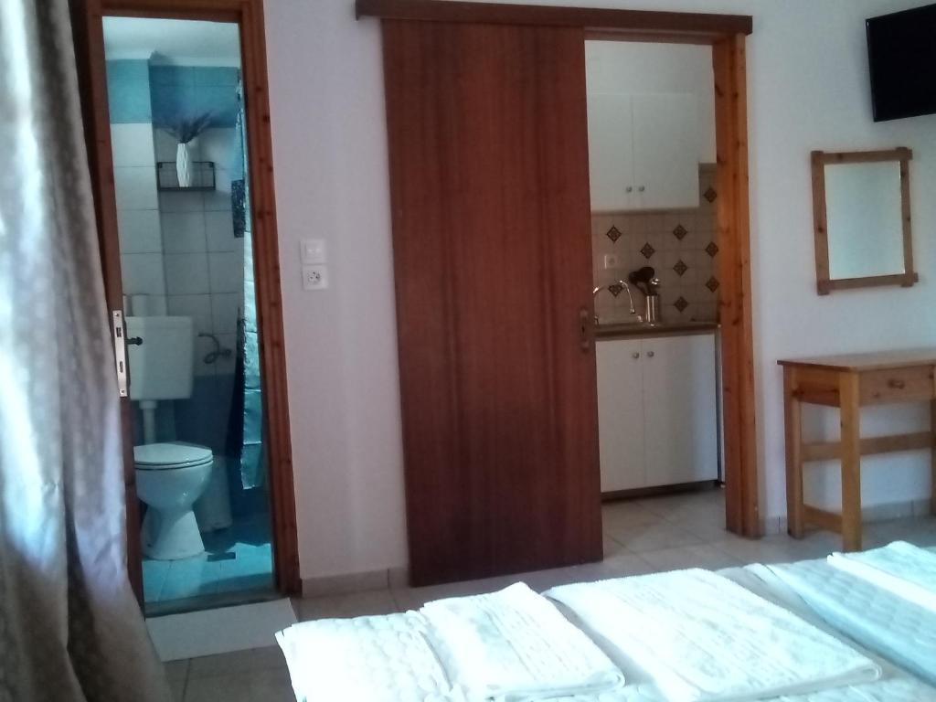 a bedroom with a bathroom with a toilet and a sink at Studios Thomas in Limenaria
