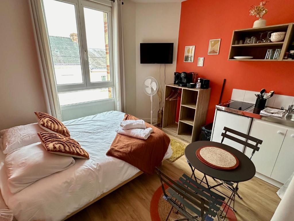 une chambre avec un lit, une table et une fenêtre dans l'établissement Le TerraCosy - Gare - BCLA, au Mans