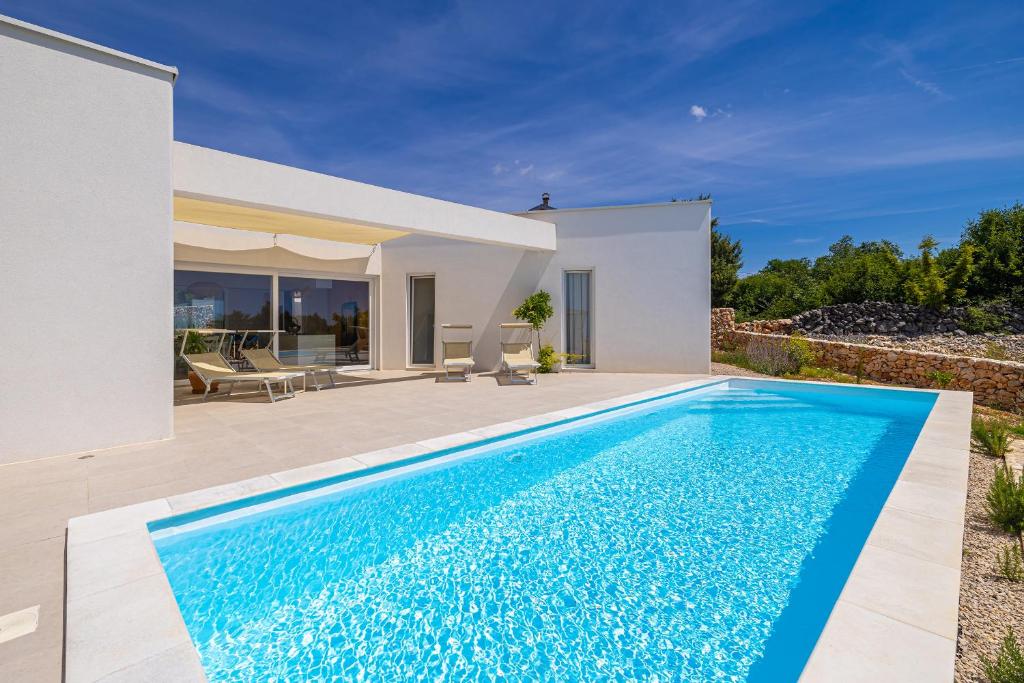 a swimming pool in front of a villa at Villa MENTA IV in Linardići