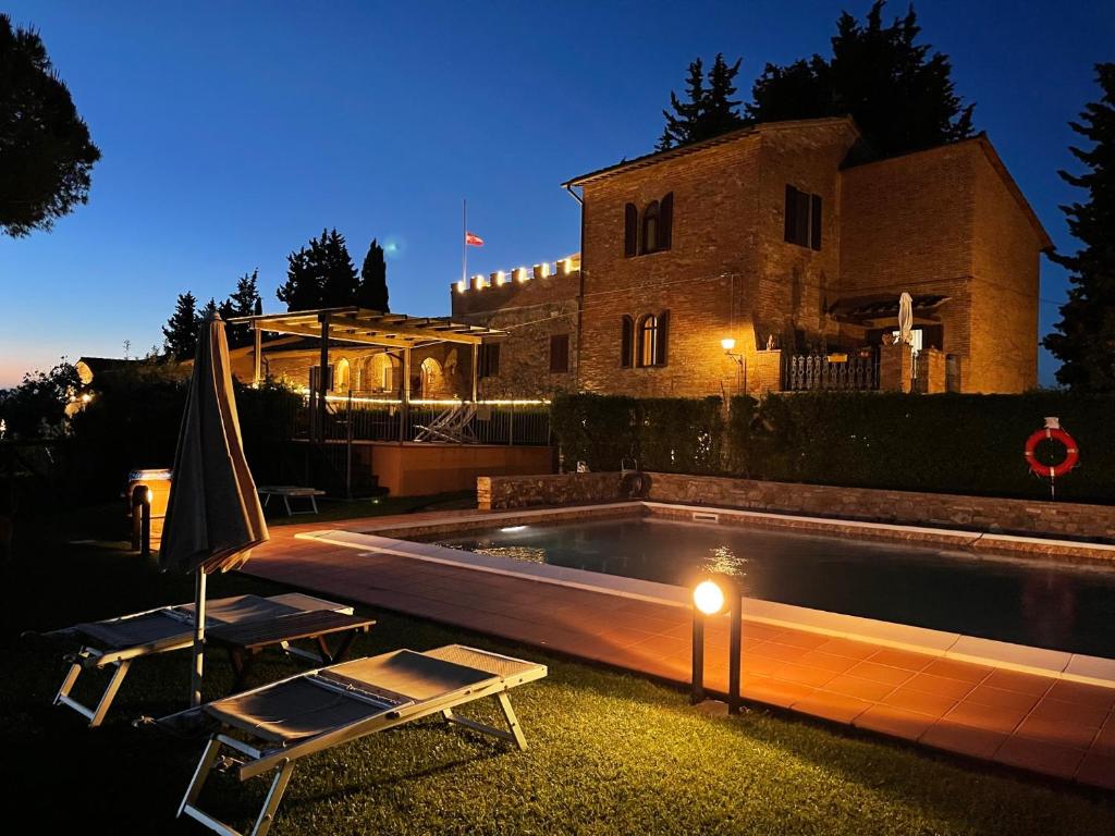 a swimming pool in front of a house at night at Fattoria Di Pancole in San Gimignano