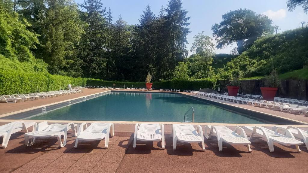 een zwembad met witte stoelen en een stapel bij location mobil-home in Saint-Chéron