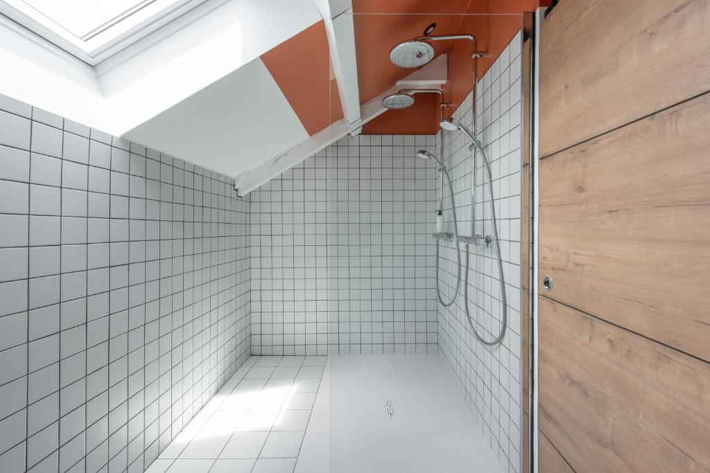 uma casa de banho com paredes em azulejos brancos e um chuveiro em Best Western Bridge Hotel Lyon East em Jons