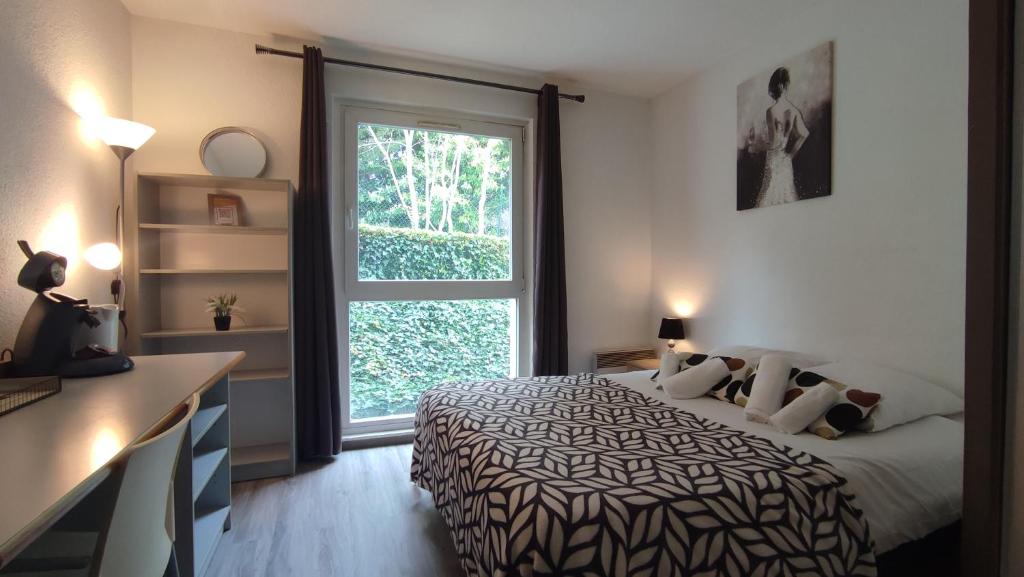 une chambre avec un lit et une grande fenêtre dans l'établissement Neoresid - Résidence du Parc, à Reims