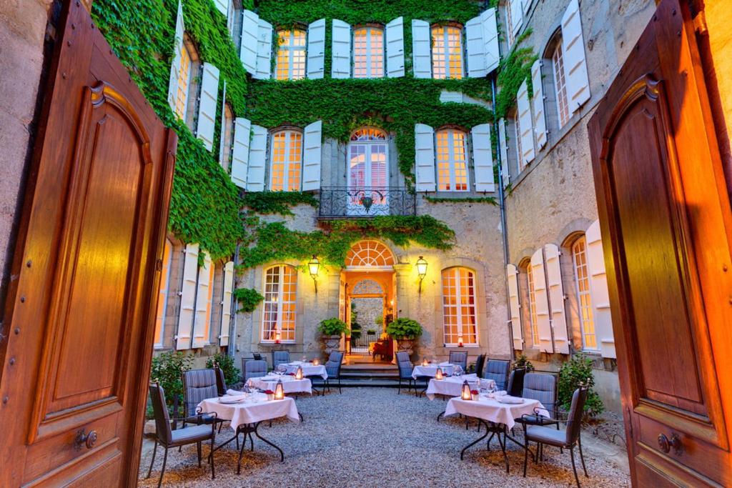 um restaurante com mesas e cadeiras num edifício em Chambres d'hôtes Relais Mira Peis em Mirepoix