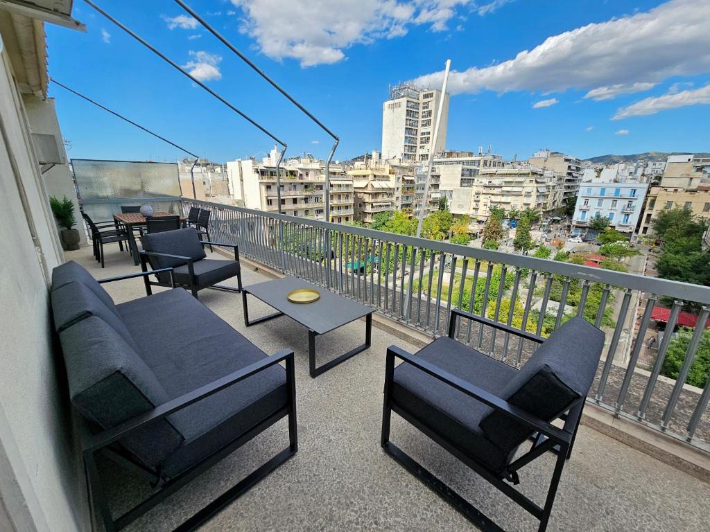 d'un balcon avec des chaises et des tables offrant une vue sur la ville. dans l'établissement Victoria Capitan Apartments, à Athènes