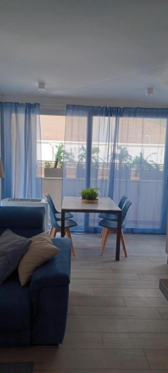 sala de estar con sofá azul y mesa en Residenza sul Mare, en Civitanova Marche