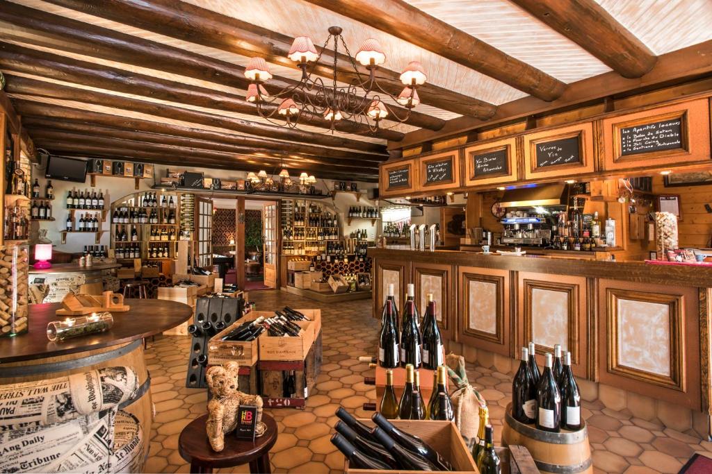 a bar with bottles of wine in a restaurant at Hotel Le Rocher Blanc in Albaret-Sainte-Marie