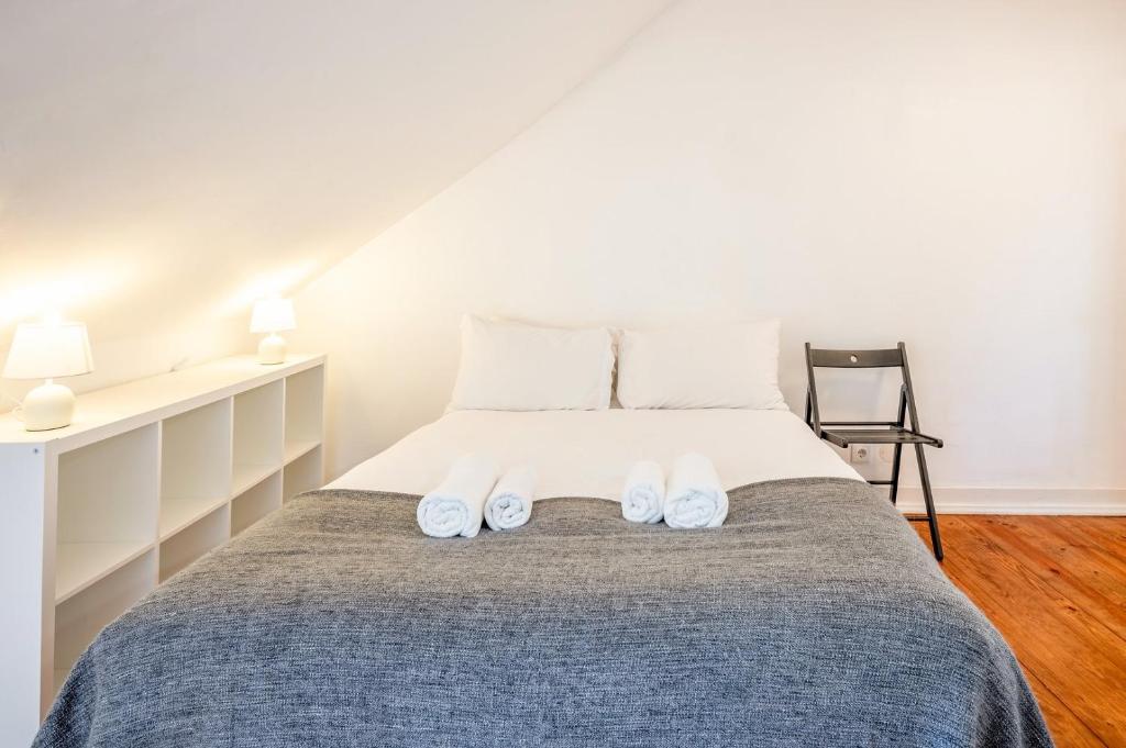 um quarto com uma cama com dois sapatos brancos em GuestReady - B-MAD Museum At Your Doorstep em Lisboa